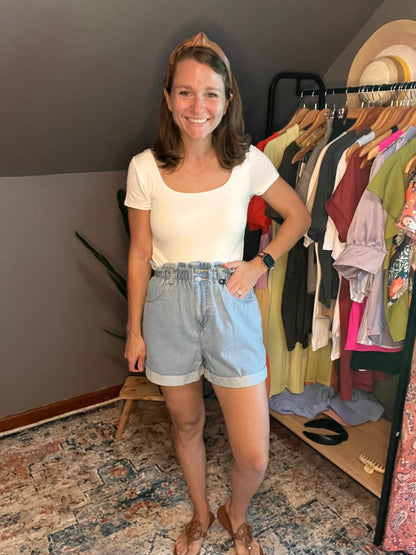 white short sleeved square neck bodysuit with blue ruffle shorts 