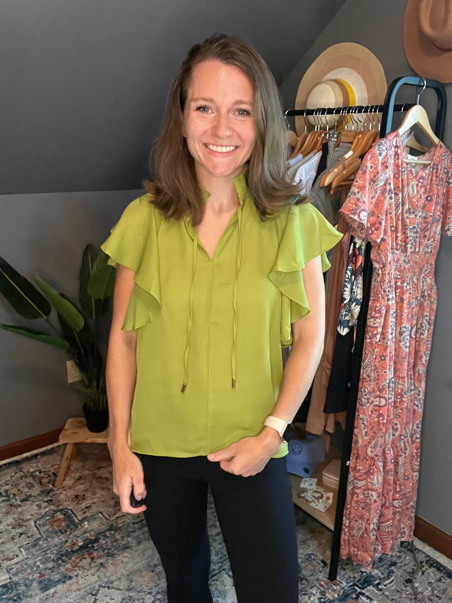 chartreuse blouse with ruffle sleeves paired with black pants