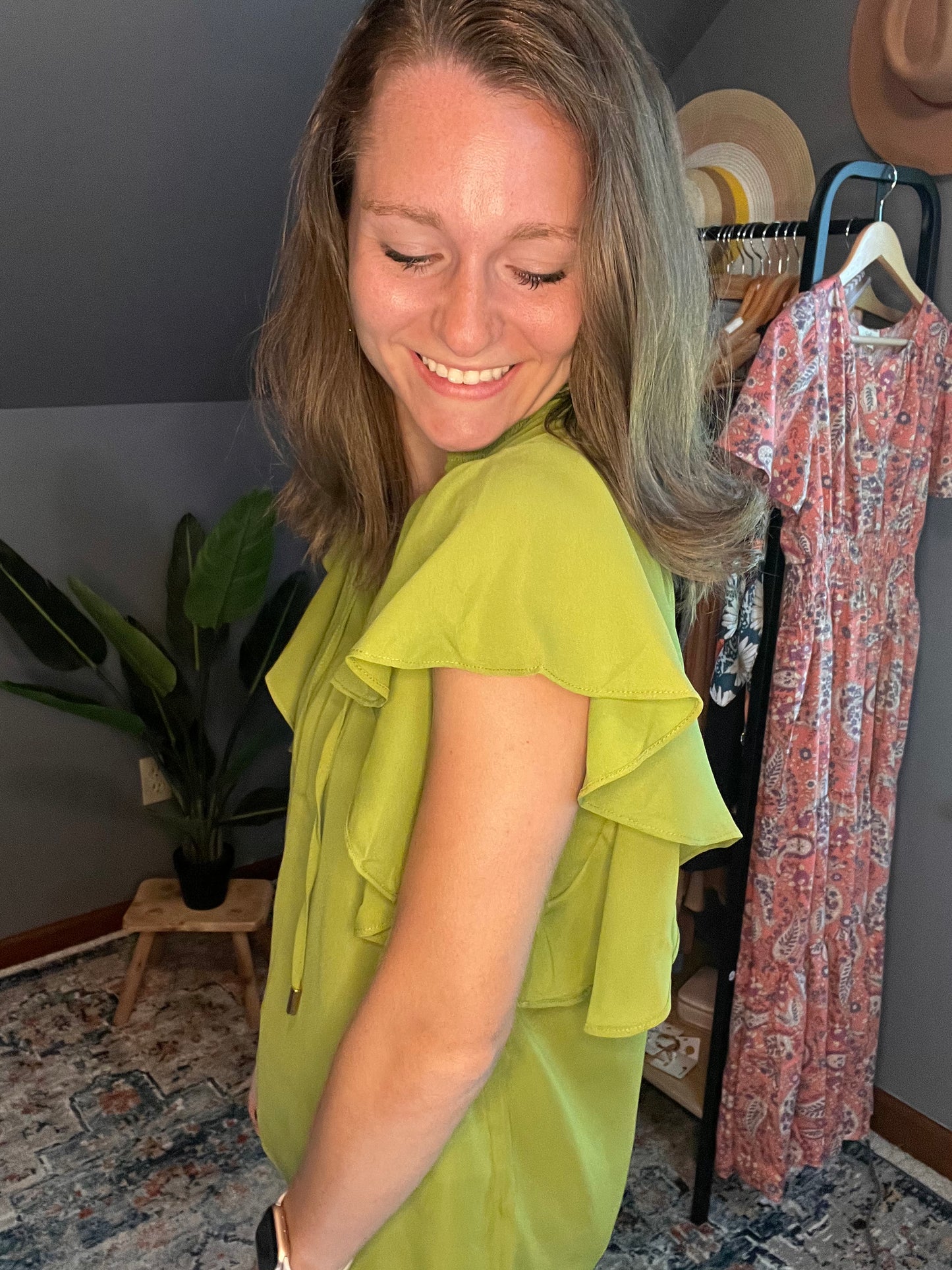 chartreuse blouse with ruffle sleeves paired with black pants