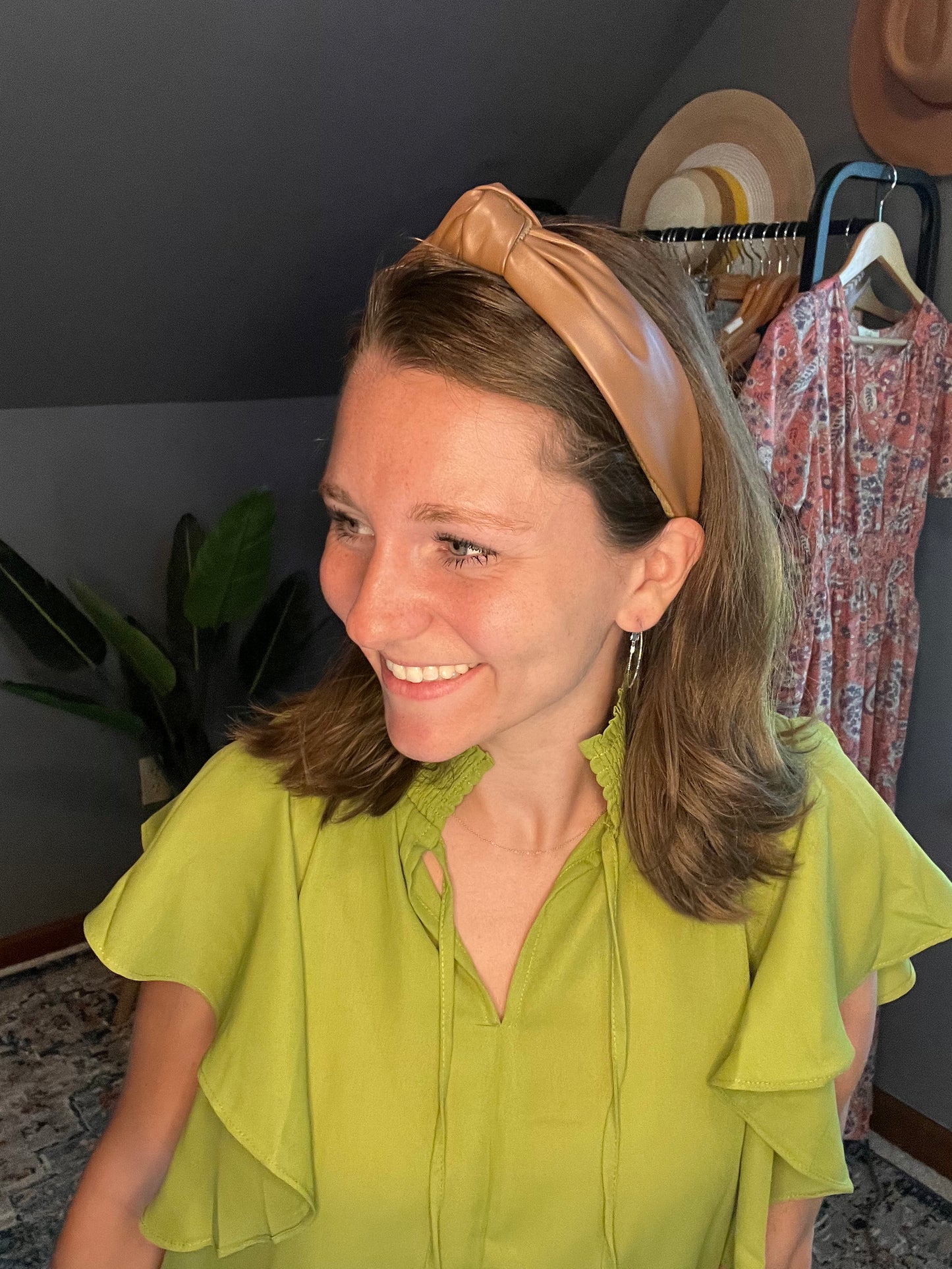 chartreuse blouse with ruffle sleeves paired with black pants and a vegan leather brown headband